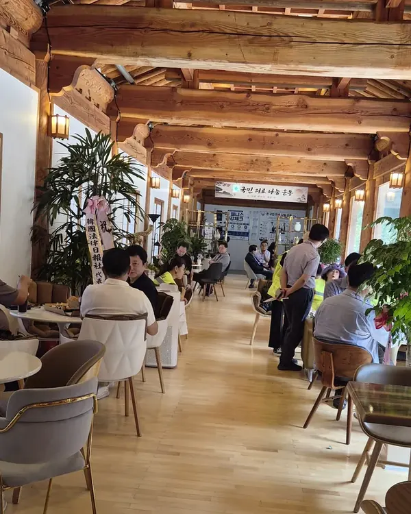 한옥 서까래 아래 손님들이 앉은 카페